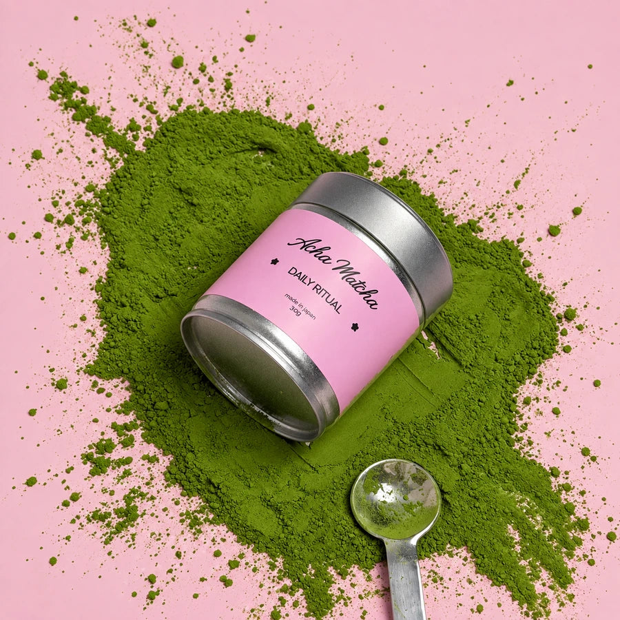 Matcha powder and a spoon beside the pink Daily Ritual tin