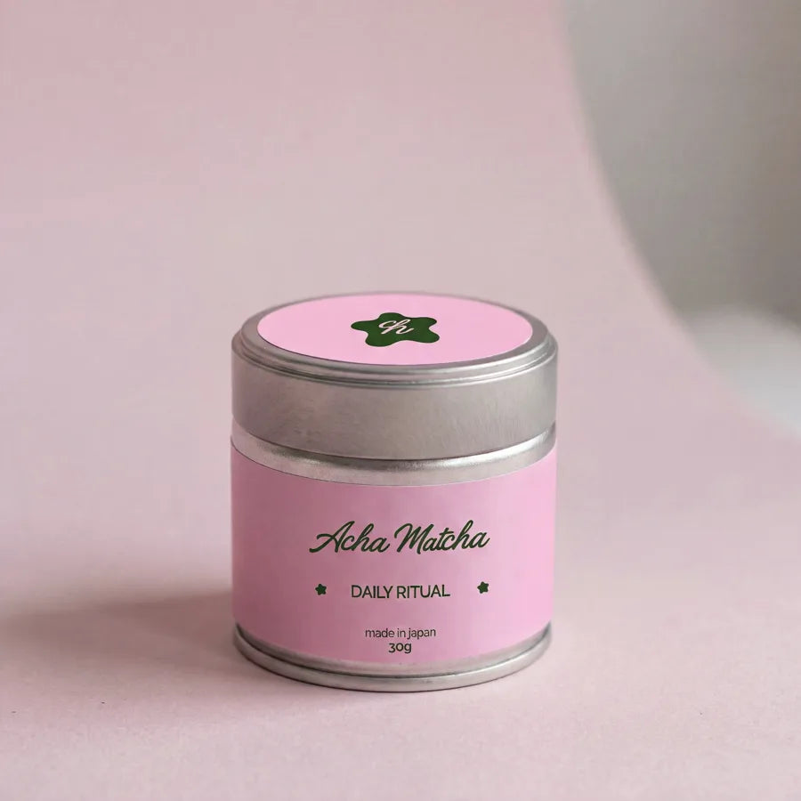 A 30g tin of Acha Matcha Daily Ritual beginning to open in soft light